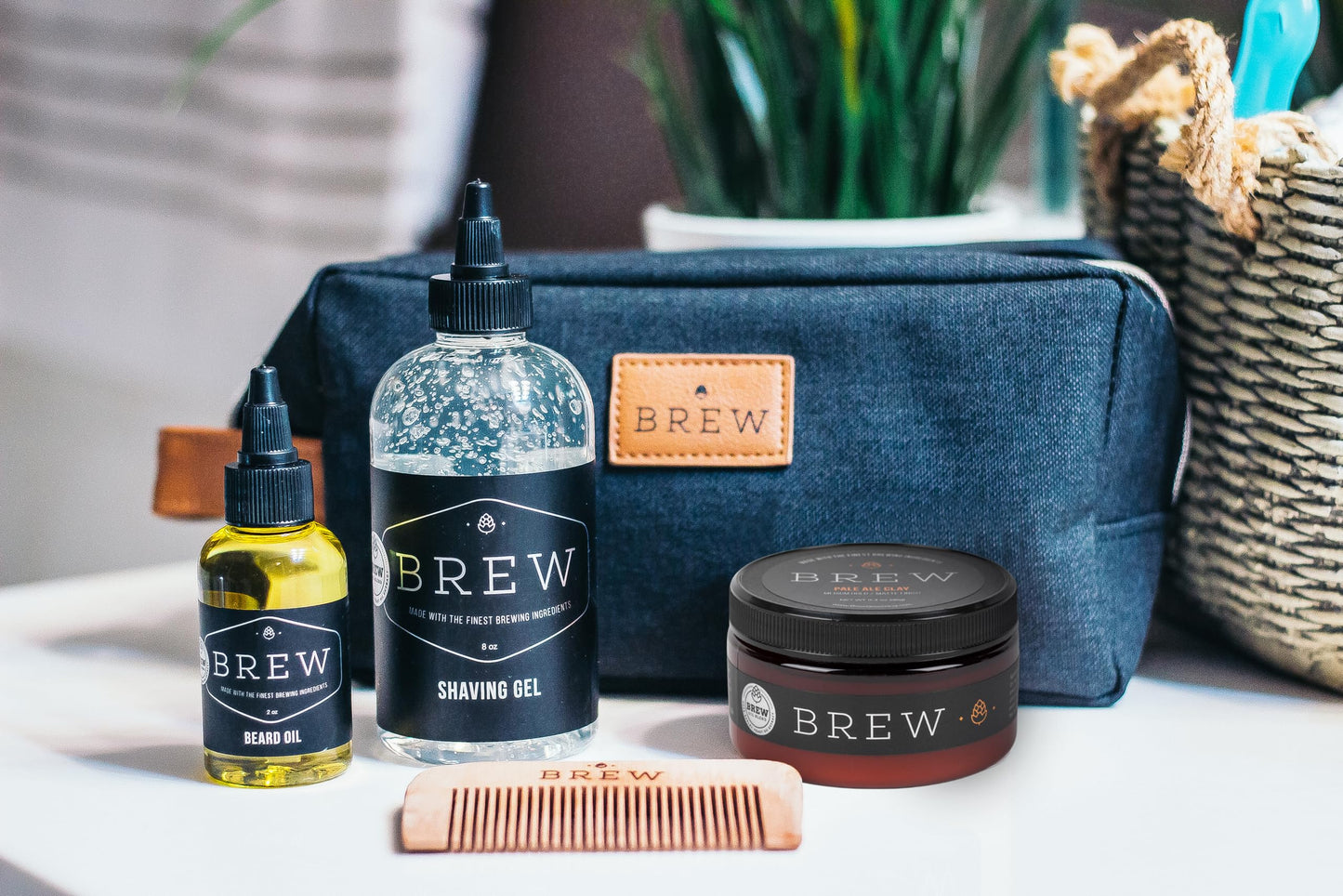 Brew grooming products including shaving gel, oil, and a jar on a table.